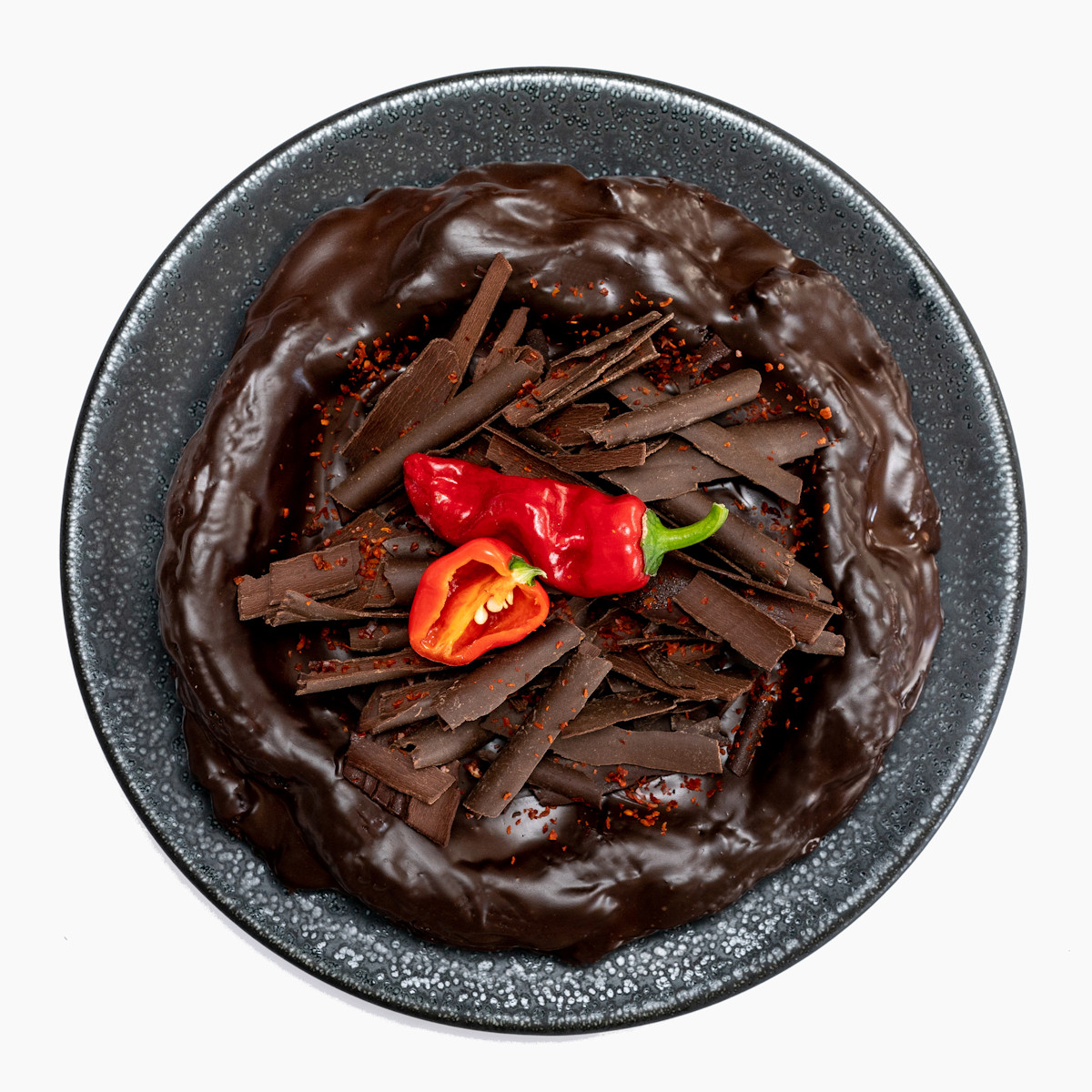 Čokodort Chilli zdobený čokoládovými hoblinami a sušenými chilli vločkami na elegantním talíři
